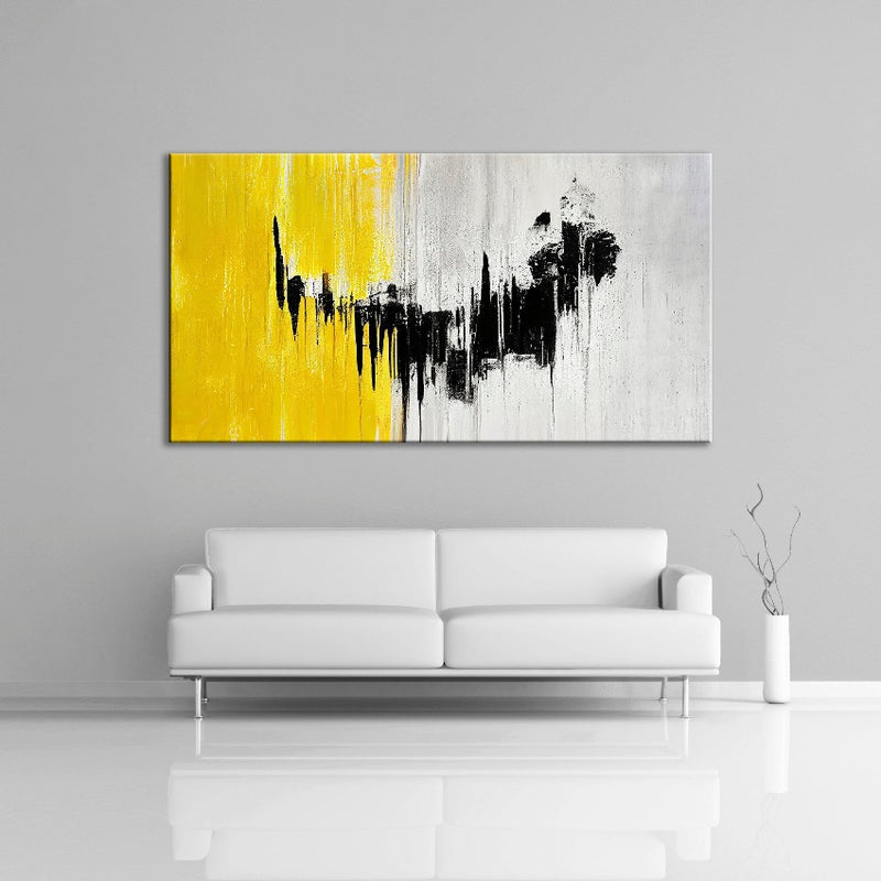 A modern abstract painting featuring the colours yellow, black and gray. Displayed over a couch.
