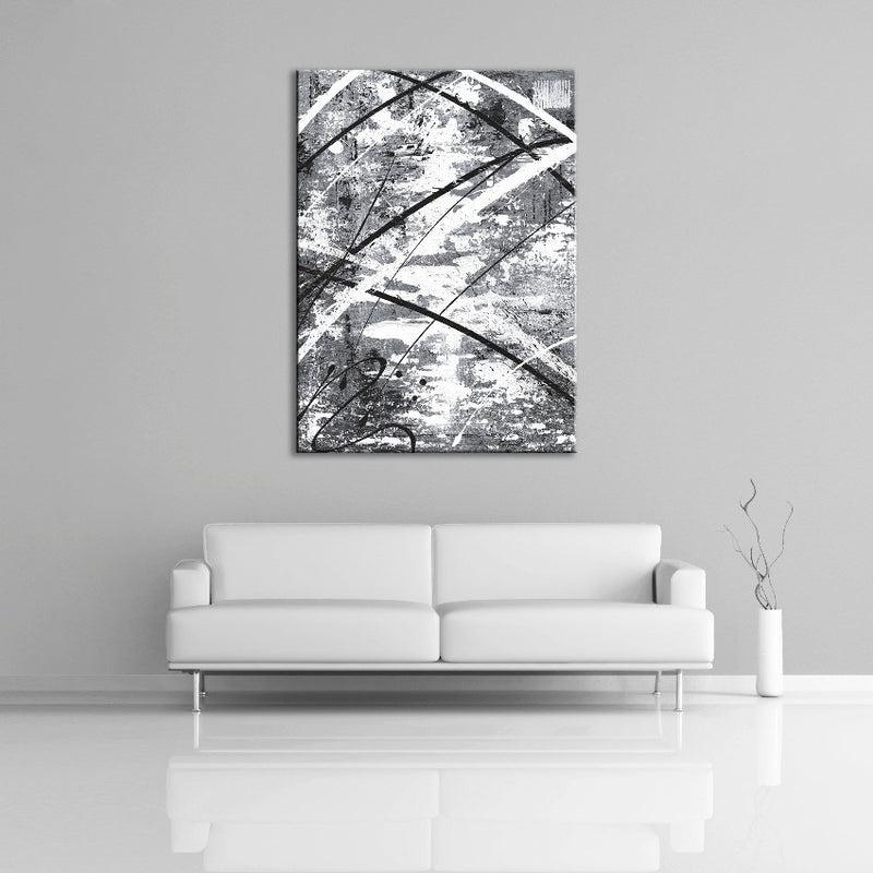 A modern abstract painting featuring the colours gray, white and black. Displayed above a couch.