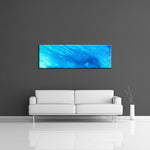A modern abstract painting featuring the colours  light and dark blue. Displayed horizontally over a couch.