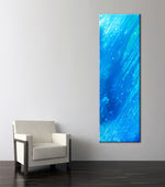 Photo of a blue and turquoise abstract painting beside a chair