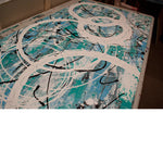 Close up image of a large, light blue and turquoise abstract, acrylic painting, featuring contemporary white circles.