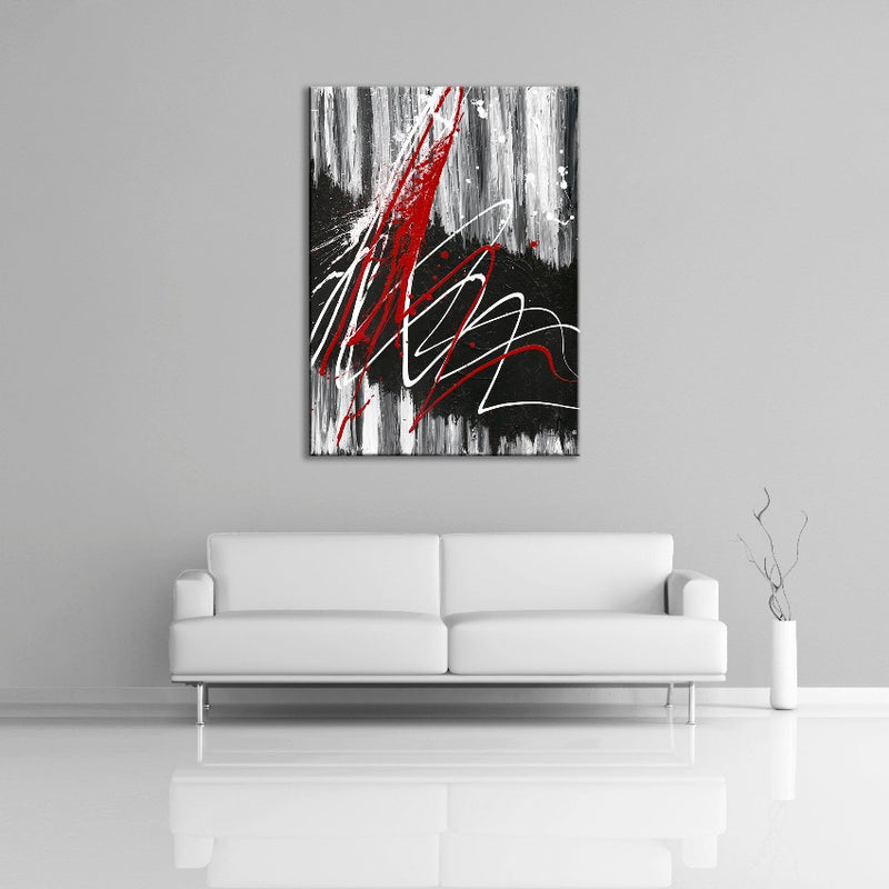A modern abstract painting featuring the colors black, white, gray and red. This painting is displayed over a couch