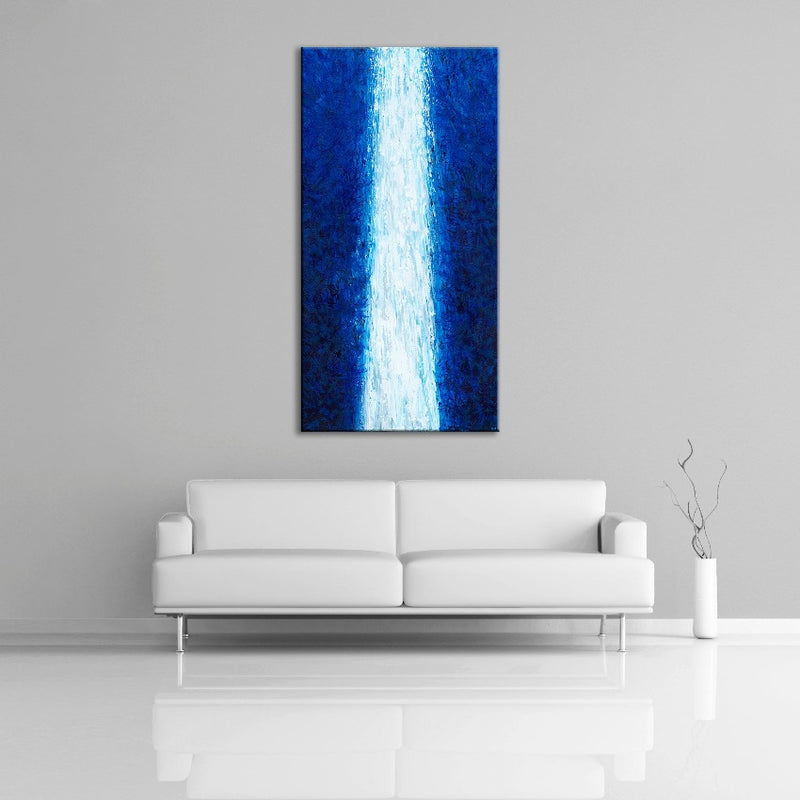 A modern abstract painting featuring the colours blue and white. Displayed over a couch.