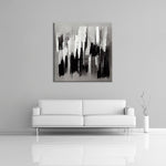 An abstract painting featuring white, black and gray displayed over a couch.