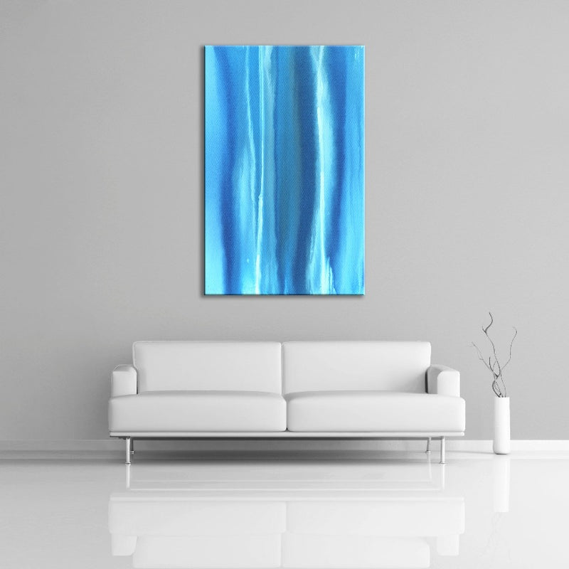 A modern abstract painting featuring the colours dark and light blue with streaks of white. Displayed over a couch.