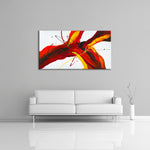 A modern abstract painting featuring the colours red, orange, yellow, black and white. Displayed over a couch.