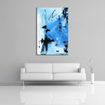 An abstract painting featuring light blue, white, and black acrylic paint. Displayed over a couch.