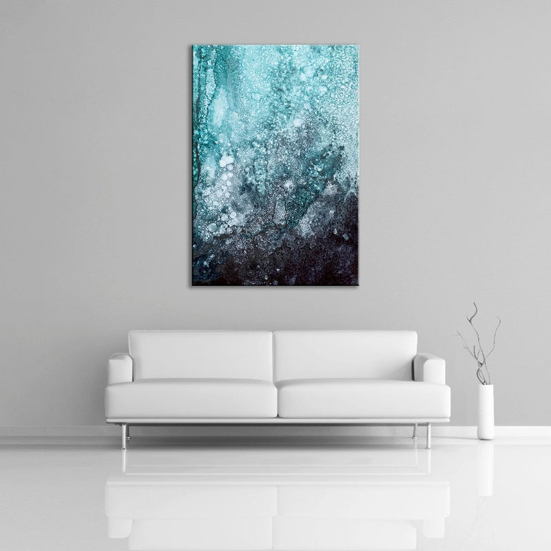 A modern abstract alcohol ink painting featuring the colours black, blue, green and white. Displayed over a couch.