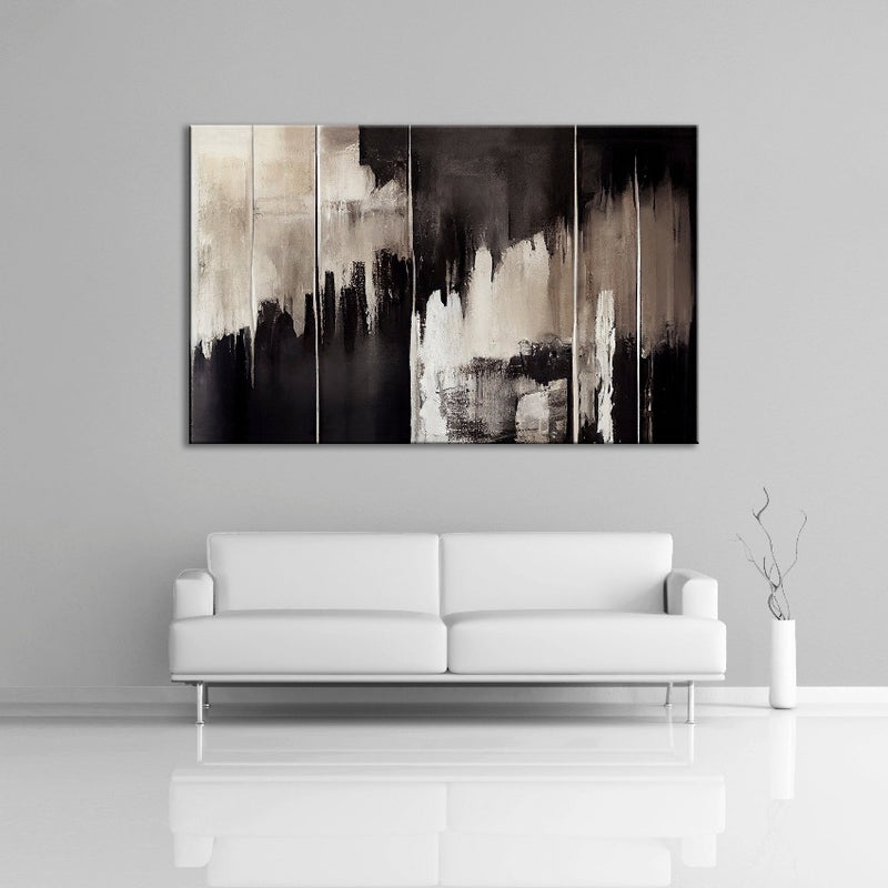 An abstract painting featuring the colors black and cream. Displayed over a couch.