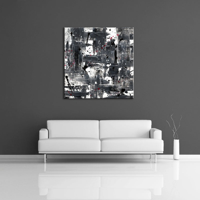 A modern abstract painting featuring the colours white, gray, black and red. Displayed over a couch.