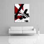 An abstract painting featuring the colours black, white and red. Displayed over a couch.