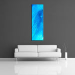 A modern abstract painting featuring the colours  light and dark blue. Displayed vertically on wall.