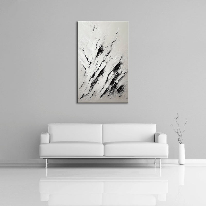 A modern abstract painting featuring the colours black and white. Displayed over a couch.