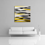 An abstract painting featuring yellow, black and white.  Displayed over a couch